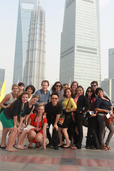 The study abroad group takes a quick photo in front of Shanghai skyscrapers.