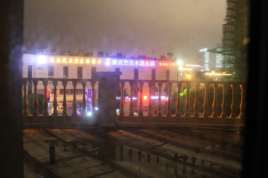 The view from my hotel room shows a neighboring building with illuminated Chinese characters.
