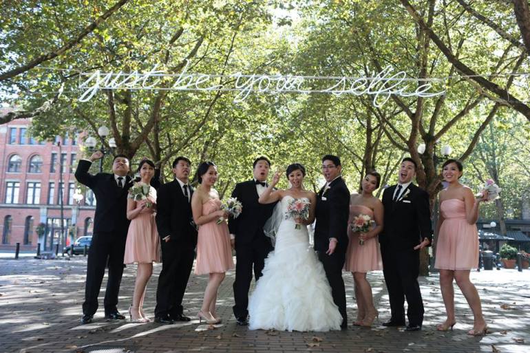The bridesmaids and groomsmen pose for a funny photo in Pioneer Square!
